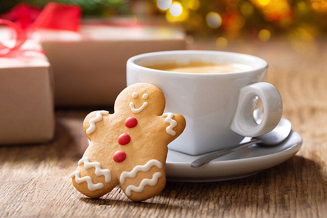 Weihnachtskeks-Männchen mit einer Tasse Kaffee.