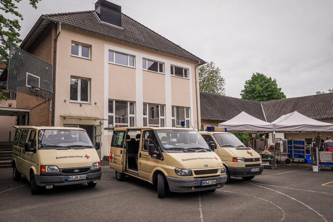 Drei Einsatzwagen auf dem Schulhof.