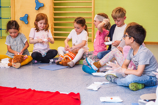 Kinder üben den Umgang mit Verbänden.