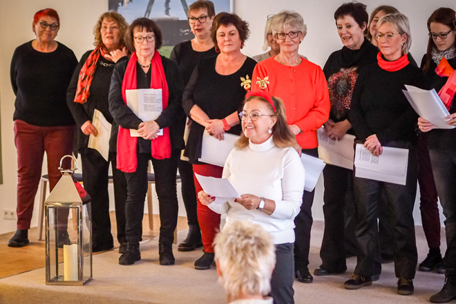 Frau mit Zettel vor einer Gruppe Frauen.