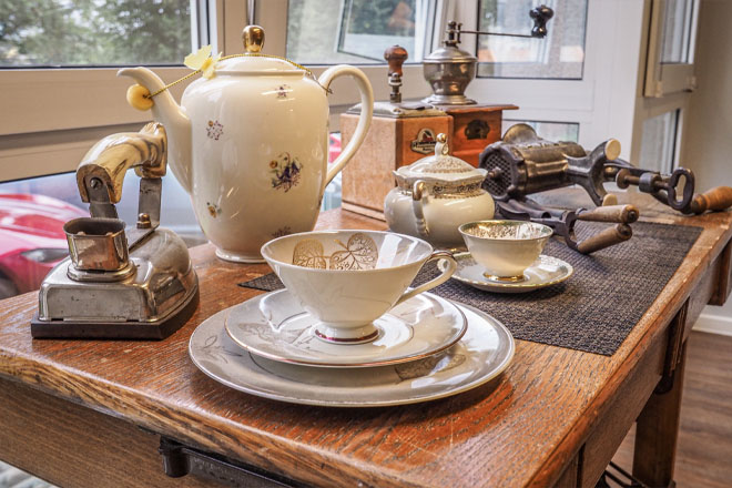 Alte Kaffeetassen, Kaffeekanne und ein altes Bügeleisen.